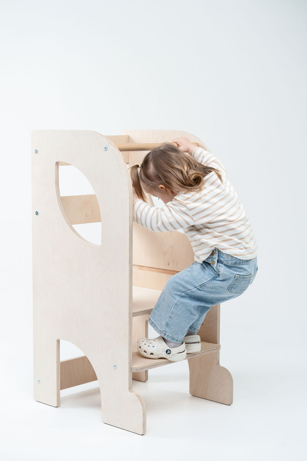 Vaikas naudoja Montessori bokštelį virtuvėje savarankiškai