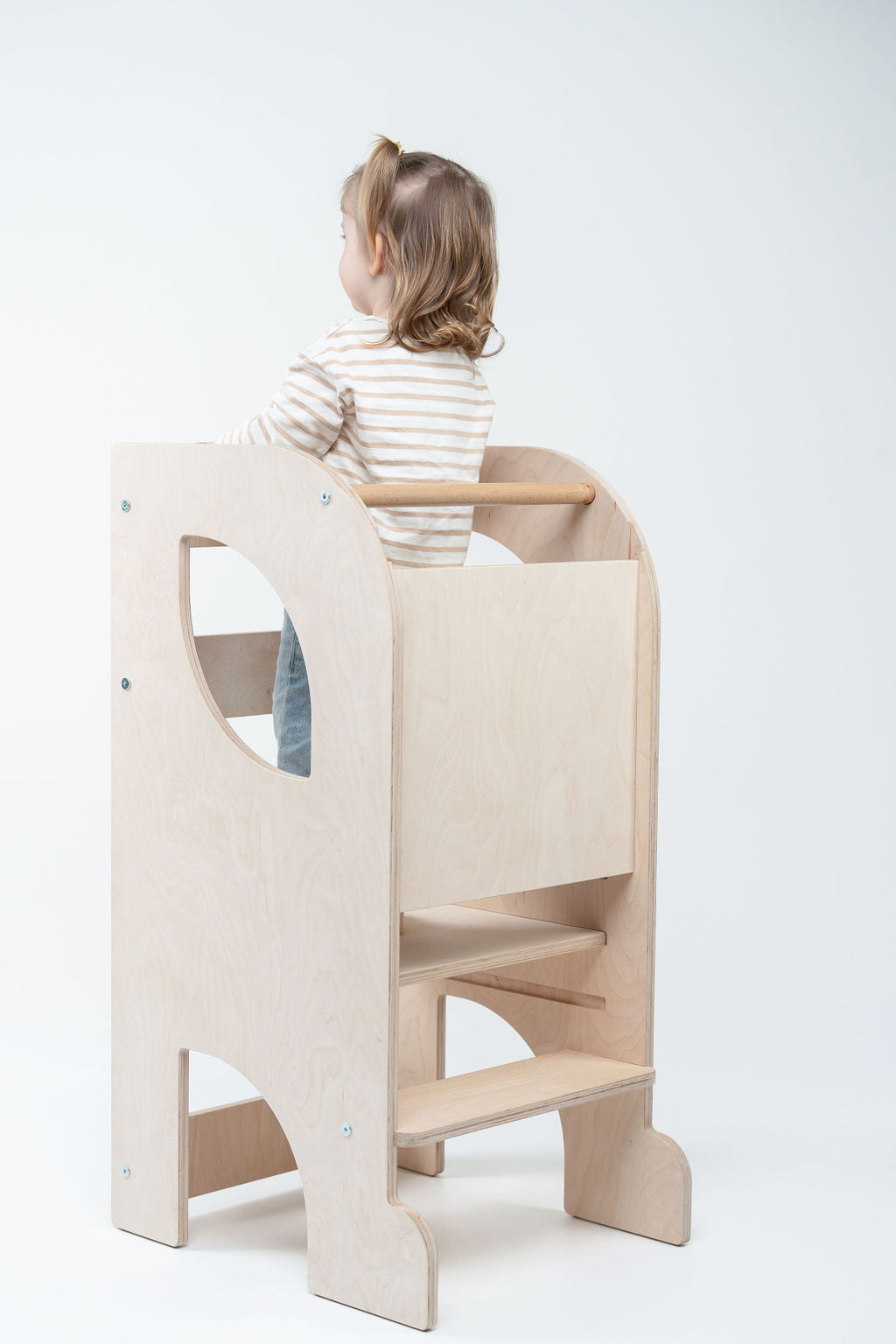 Vaikas naudoja Montessori bokštelį virtuvėje savarankiškai